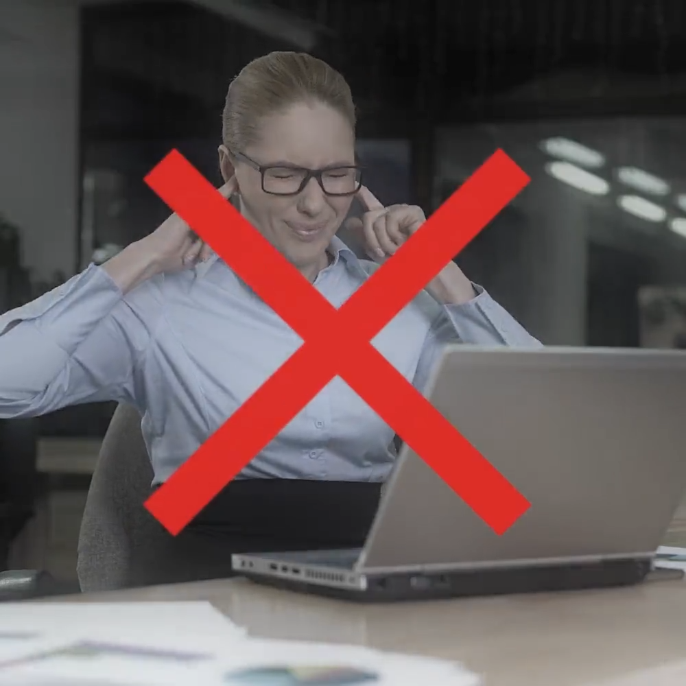 Woman frustrated by loud noisy air conditioner at work – showing the problem EpiCooler solves with ultra-quiet operation